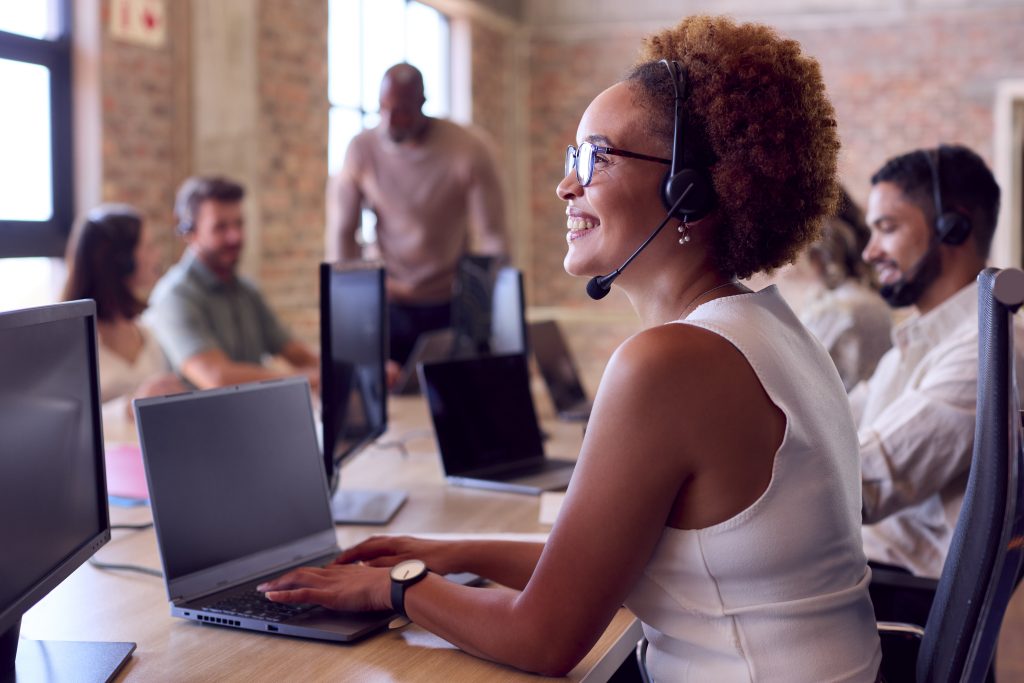 Multi-Cultural Business Team Wearing Headsets Working In Customer Support Centre